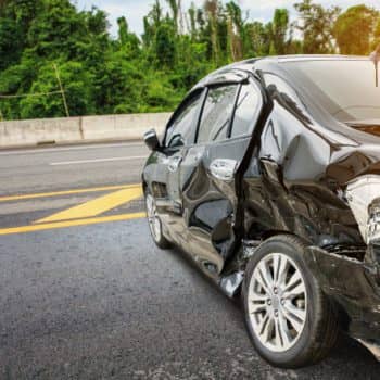 Car with severe side damage after highway crash