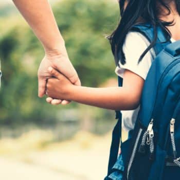 Mother daughter on way to school with backpack