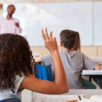 Child raising her hand in class