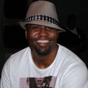 Smiling man wearing fedora and white t-shirt