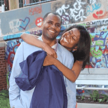 Happy couple embracing near colorful graffiti wall