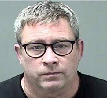 Man with glasses in front of plain background