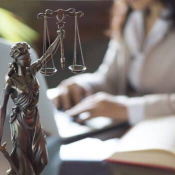 Lawyer at desk with Lady Justice statue
