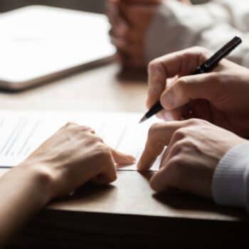 People signing papers at table
