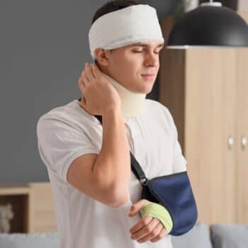 Man With A Bandaged Head And Arm In Pain