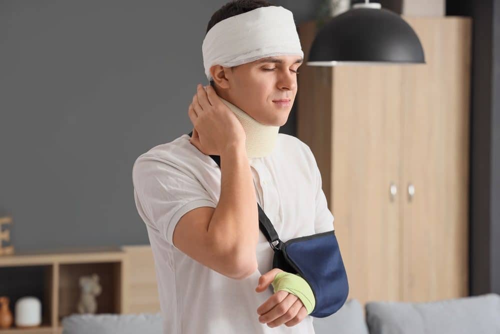 Man With A Bandaged Head And Arm In Pain