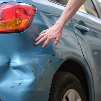 Owner checking dented bumper