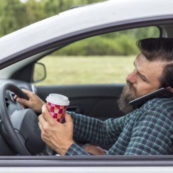 Young man talking on the phone while driving